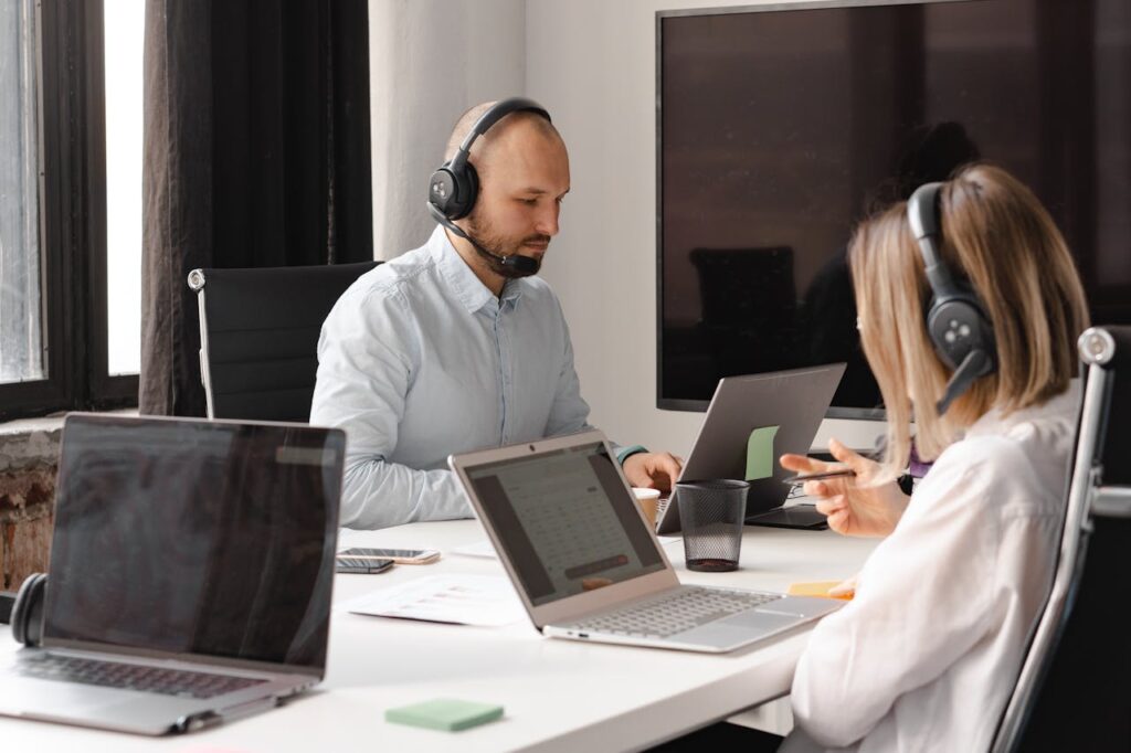centrics-business-solutions-support-service Customer support agents working together with laptops and headsets in an office setting.